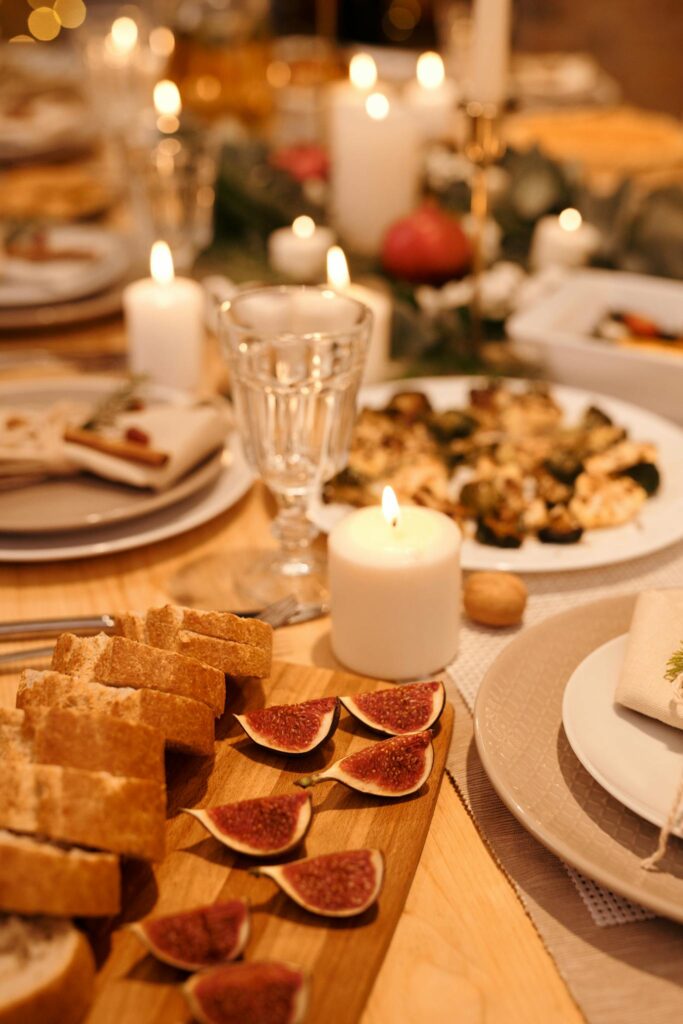 Warm and inviting Christmas dinner setup with candles, bread, figs, and a festive atmosphere.
